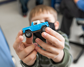 Tripp Chase holding a toy blue truck while at Children's Mercy.