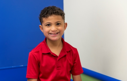 Hezekiah, an 8-year-old patient at Children's Mercy, smiles broadly in an exam room.