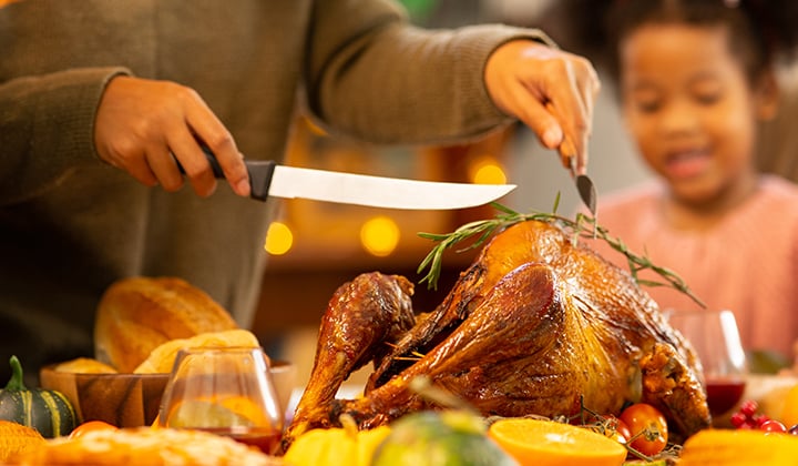 Mom carving a turkey at a meal