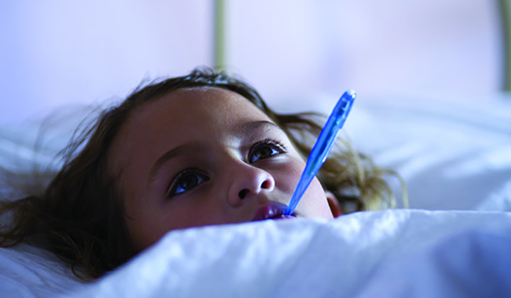 Girl in bed with thermometer