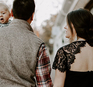 parents holding hands and dad holding baby