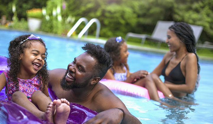 Happy family swimming in a pool together