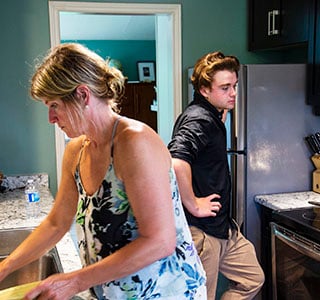 Teen and mom in kitchen cleaning