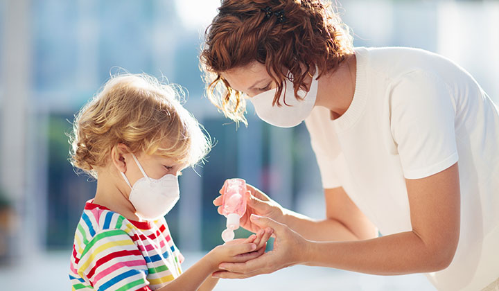 Mom putting hand sanitizer in child's hand