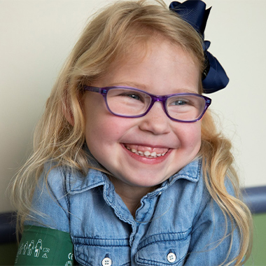 Little girl with glasses smiling